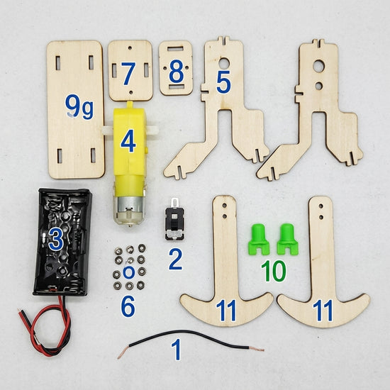 TippyBot kit components laid out — DC motor, crank shaft, wooden frame pieces and wheels