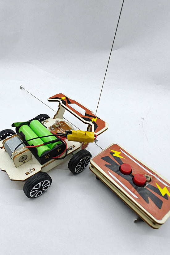 Wood Racer V1 close-up — wooden frame, motor wiring, and rubber racing wheels